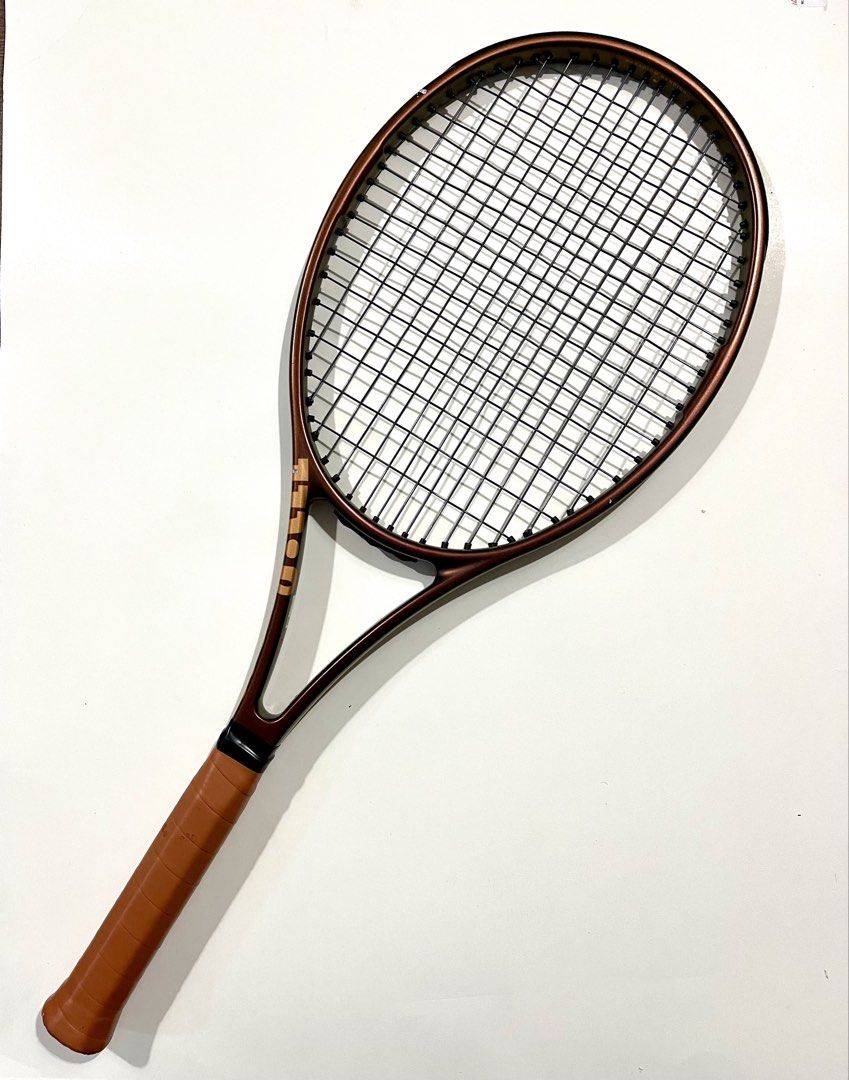Wilson Pro Staff V14 Tennis Racket (Category: Racket and Ball Sports) located in Cebu City. Submitted by adriano.adriano (Listing ID 1466220466, Image 1). Description: - original Wilson Pro Staff V14 tennis racket - Color: Metallic bronze finish - Grip Size: 3 4/8 - Setup: Strung and ready for play with a premium leather grip installed - Condition: Good structural condition with minor scuffs and paint chips on the top hoop (just cosmetic wear fro