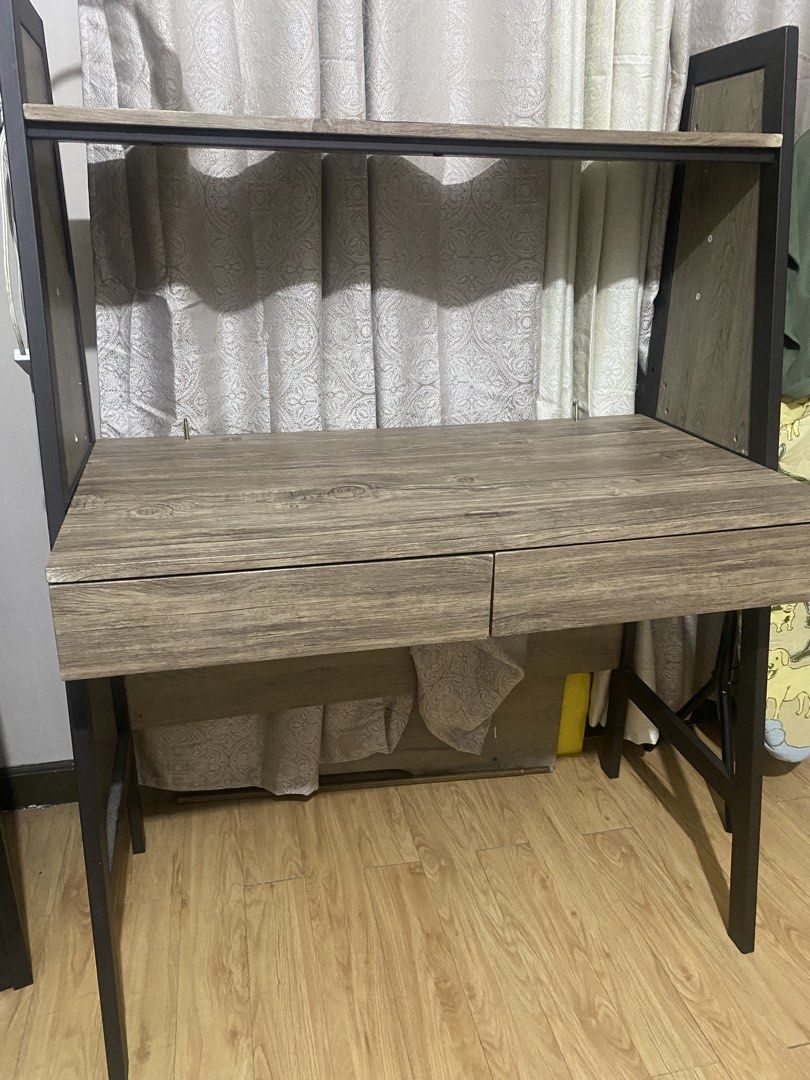 Wooden Study Desk with Shelf and Drawers (Category: Tables & Sets) located in Bacoor. Submitted by thalia.maria (Listing ID 1466331364, Image 1). Description: - Material: Warm wood grain finish with a sturdy black metal frame - Storage: 2 pull-out drawers and a convenient top shelf for extra space - Design: Clean lines and solid build with strong, stable legs - Ideal For: Bedrooms, home offices, or study rooms.