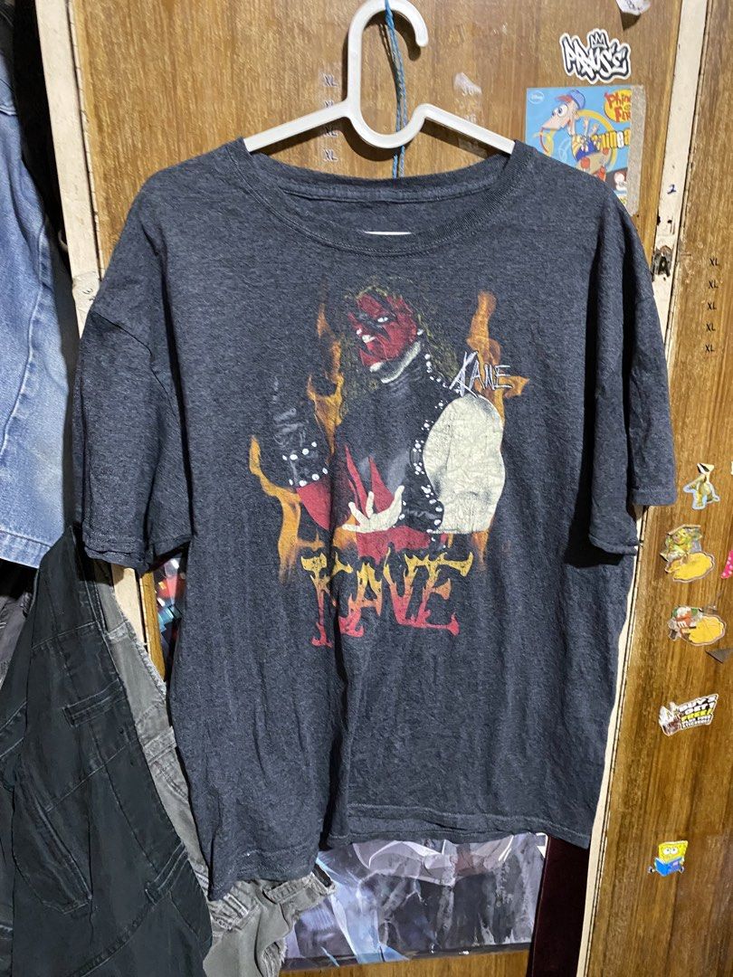 WWE Kane Graphic Tee Dark Grey (Category: Tshirts & Polo Shirts ) located in Imus. Submitted by frootiloots4103 (Listing ID 1466209300, Image 1). Description: - Design: Large front graphic of Kane surrounded by flames with distressed lettering - Color/Style: Dark grey with a trendy faded wash - Size: Large (printed WWE neck tag) 23x28 - Fit: Regular crew neck with short sleeves - Condition: Clean fabric, well-maintained OPEN FOR NEGO (best if asp