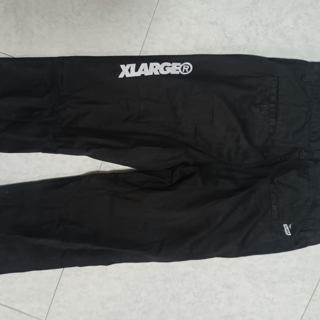 Xlarge Black Workwear Pants Size 32 (Category: Trousers) located in Alaminos. Submitted by andreid12 (Listing ID 1466287561, Image 1). Description: - Brand: Xlarge - Size: 32 (Waistband tag) - Material: Sturdy cotton twill with cream patterned inner lining - Fit: Straight leg cut - Design: Big white Xlarge logo printed on back right leg, woven brand label on back pocket - Closure: Standard button and zip fly.