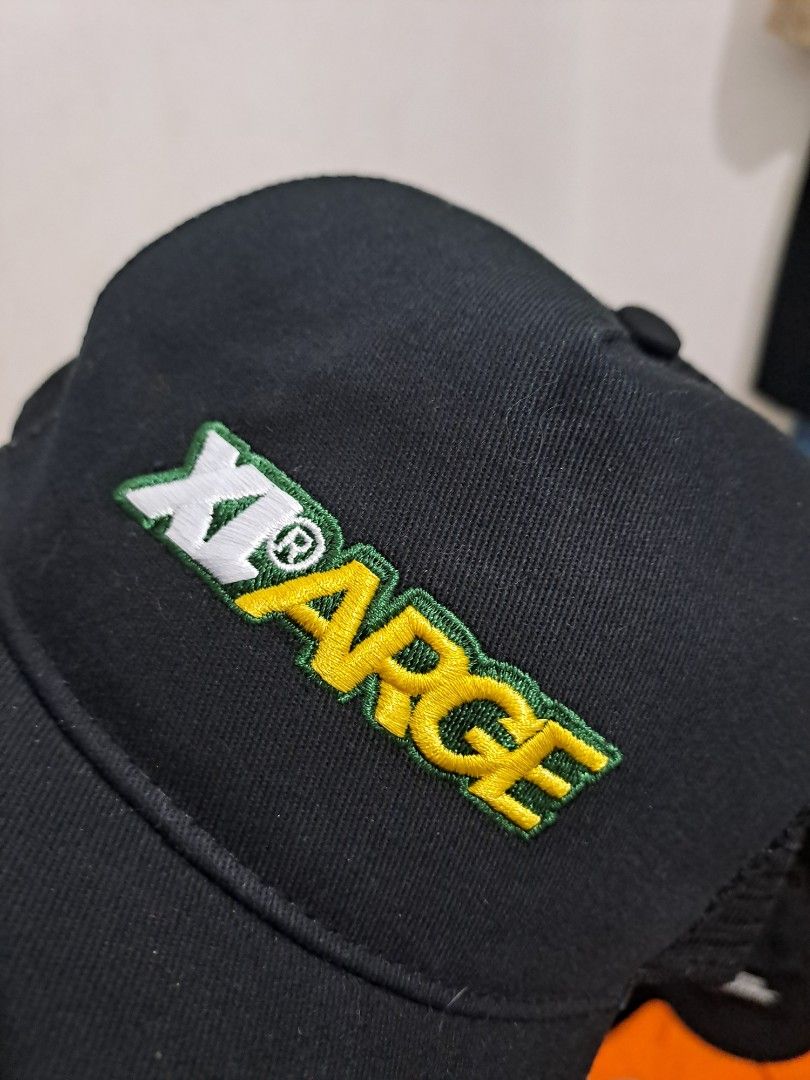 X-Large Trucker Hat (Category: Caps & Hats) located in Puerto Princesa. Submitted by jercksthriftph (Listing ID 1466330159, Image 2). Description: - Brand: X-Large Los Angeles - Condition: Brand new with original tags attached - Design: Black mesh trucker hat with green/yellow embroidered logo and white outline - Features: Curved brim, adjustable snapback closure, and branded interior taping - Size: One size fits all - Perfect for daily streetwea