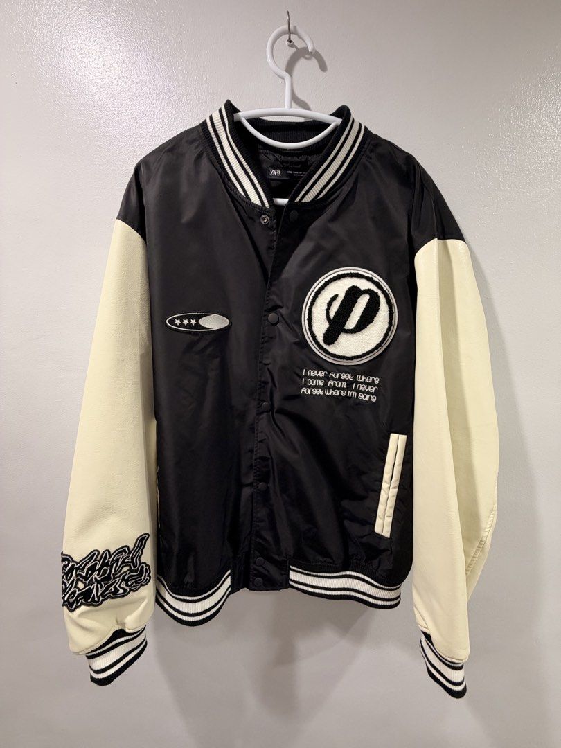 Zara Black and White Varsity Jacket (Category: Coats, Jackets and Outerwear) located in Manila. Submitted by gynzixela (Listing ID 1466204824, Image 1). Description: - Brand: Zara - Style: Varsity / Bomber Jacket - Color: Black body with off-white faux leather sleeves - Closure: Snap button front - Details: Embroidered chest patches with 'I never forget where I come from, I never forget where I'm going' text - Back Design: 'Since 1975' embroidere