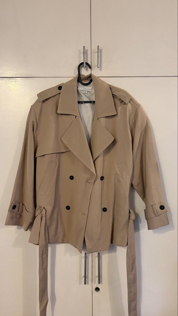 Zara Cropped Trench Jacket Beige (Category: Coats, Jackets and Outerwear) located in Taguig. Submitted by pfb__ (Listing ID 1466170803, Image 1). Description: - Brand/Style: Zara cropped trench jacket in beige - Design: Double-breasted front with dark tortoiseshell buttons - Details: Classic lapels, shoulder epaulets, storm flaps, and adjustable sleeve straps - Fit/Material: Lightweight with inner lining and a matching waist tie belt Sizing runs 
