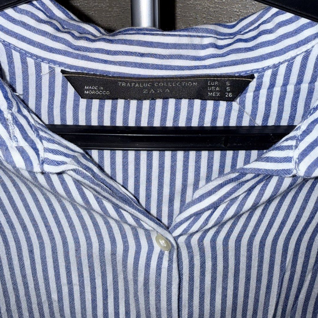 Zara Trafaluc Striped Button Down Shirt (Category: Shirts) located in Manila. Submitted by she_alice (Listing ID 1466326387, Image 3). Description: - Brand: Zara Trafaluc - Size: Small (S) runs big - Color: Classic blue and white stripes - Fit: Relaxed fit - Details: Long sleeves, button-down front, single chest pocket - - Condition: Excellent, no noticeable signs of use. -Super pretty in actual. 💬 Feel free to message me for any questions 🛵 Ca
