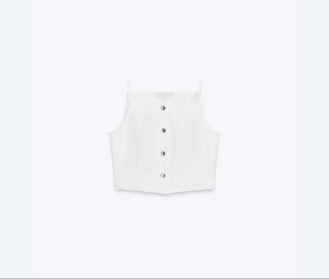 Zara Waistcoat (Category: Sleeveless) located in Caloocan City. Submitted by athenaxartemis (Listing ID 1466290219, Image 3). Description: - Brand: Zara - Color: Crisp White - Design: Square neckline, thin shoulder straps, structured paneling - Details: Functional gold-toned front buttons - Style: Clean minimalist aesthetic, perfect for pairing with high-waisted trousers or skirts - Condition: Excellent.