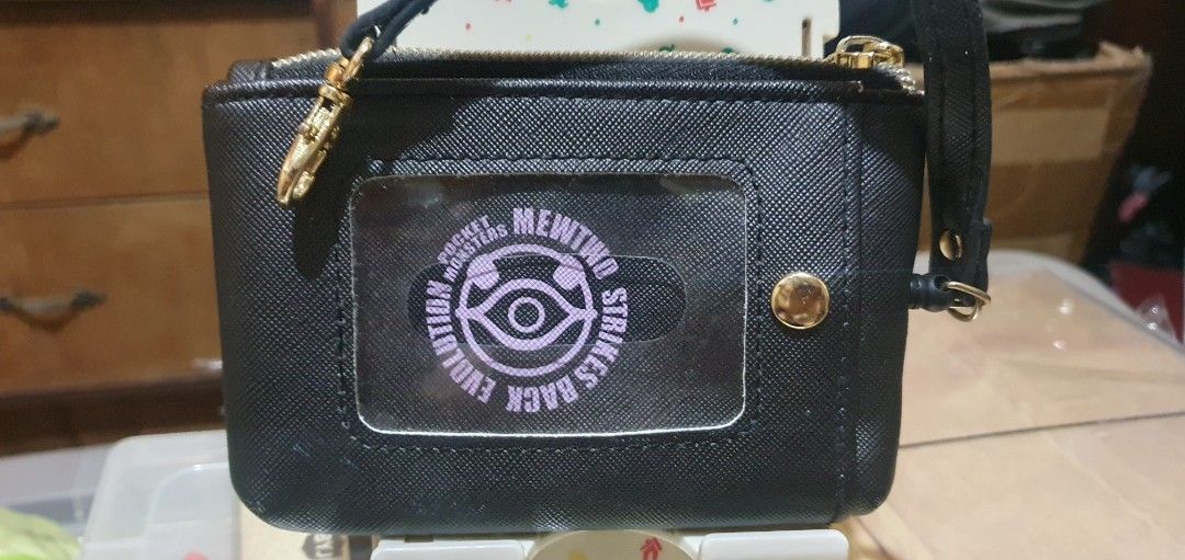 2019 Mewtwo Strikes Back Evolution Pass Case (Category: Character Goods) located in Quezon City. Submitted by collectionneursonline88 (Listing ID 1466402651, Image 2). Description: - Authentic Pokémon Mewtwo Strikes Back Evolution merchandise - Material: Premium black textured faux leather with gold-tone zipper hardware - Design: Purple Mewtwo graphic print on front and clear ID window with circular Pocket Monsters logo insert on back - Functiona