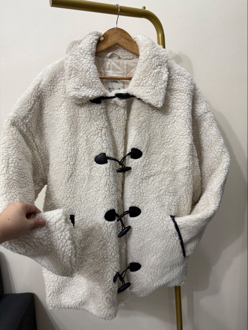 Abercrombie & Fitch Sherpa Toggle Coat (Category: Coats, Jackets and Outerwear) located in Antipolo. Submitted by jackiestash2 (Listing ID 1466468849, Image 2). Description: - Brand: Abercrombie & Fitch - Size: XL (Oversized fit) - Color: White sherpa with dark trim details - Lining: Quilted inside for extra warmth - Closure: Black horn buttons with loop fasteners - Pockets: Two functional side pockets Antipolo Gcash/Bdo Lalamove/J&T.
