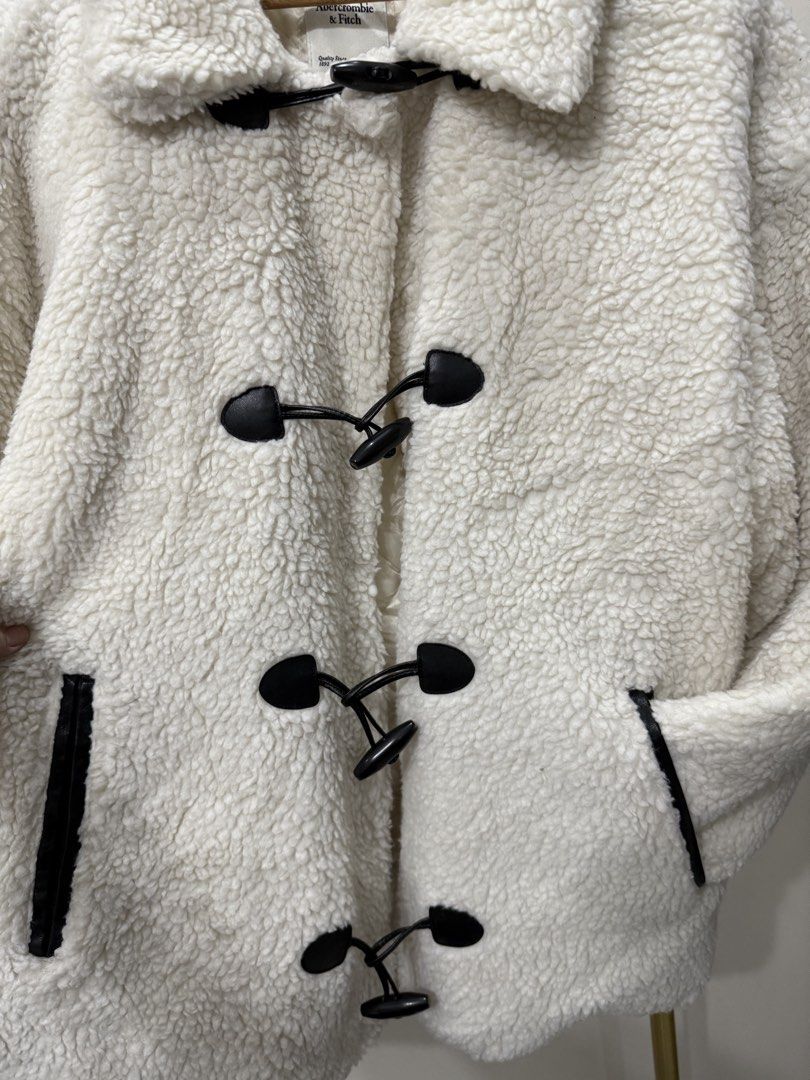 Abercrombie & Fitch Sherpa Toggle Coat (Category: Coats, Jackets and Outerwear) located in Antipolo. Submitted by jackiestash2 (Listing ID 1466468849, Image 3). Description: - Brand: Abercrombie & Fitch - Size: XL (Oversized fit) - Color: White sherpa with dark trim details - Lining: Quilted inside for extra warmth - Closure: Black horn buttons with loop fasteners - Pockets: Two functional side pockets Antipolo Gcash/Bdo Lalamove/J&T.