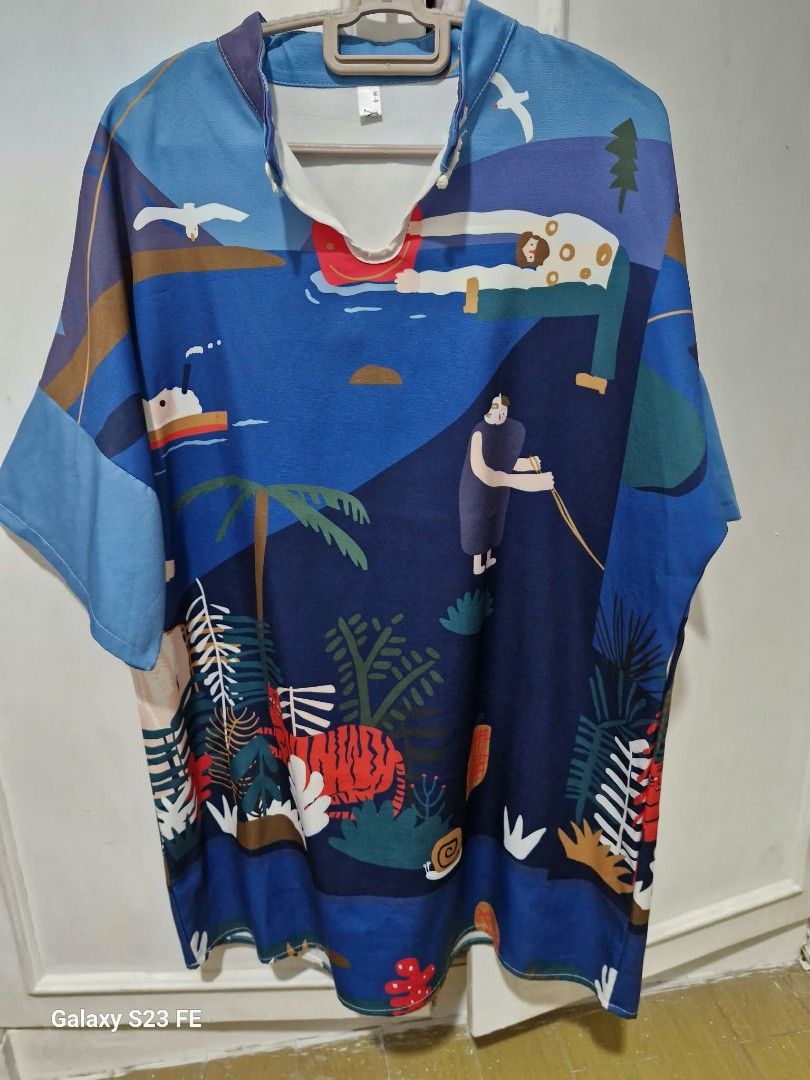Abstract Art Print Oversized Short Sleeve Shirt (Category: Shirts) located in Binangonan. Submitted by everythingmustgo78 (Listing ID 1466410321, Image 1). Description: - Vibrant blue shirt with unique abstract scenery print (swimming people, boats, palm trees, and tiger) - Relaxed, loose fit with short sleeves for ultimate comfort - Stylish V-neck collar accented with contrasting white trim - Lightweight and breathable fabric - Ideal for sunny d