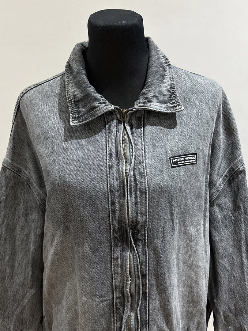 Active Vogue Grey Acid Wash Denim Zip Jacket (Category: Coats, Jackets and Outerwear) located in Manila. Submitted by mpt99876 (Listing ID 1466522593, Image 2). Description: - Colour: Grey acid wash - Fit: Relaxed, oversized with dropped shoulders - Closure: Full front zipper with classic collar - Details: Small black Active Vogue patch on left chest - Hem: Elasticated bottom hem - Sleeves: Long sleeves with solid grey back.