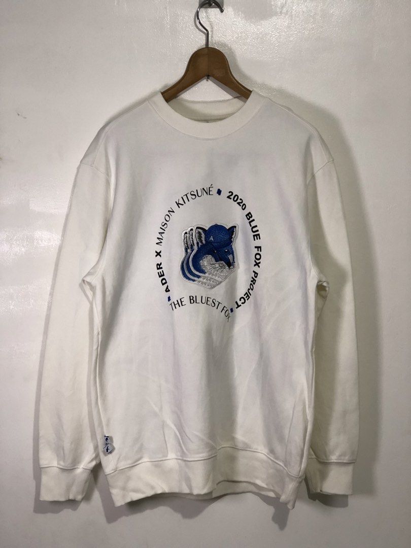 Ader Error x Maison Kitsune Blue Fox Project Sweatshirt (Category: Coats, Jackets and Outerwear) located in Quezon City. Submitted by clarizedeo09960 (Listing ID 1466502689, Image 1). Description: - Brand: Ader Error x Maison Kitsune Collaboration - Color: White - Material: Premium cotton - Design: Large embroidered blue fox graphic with circular typography - Details: Ribbed collar, cuffs, hem, and iconic blue brand tag - Size: Tagged A1 - Origin
