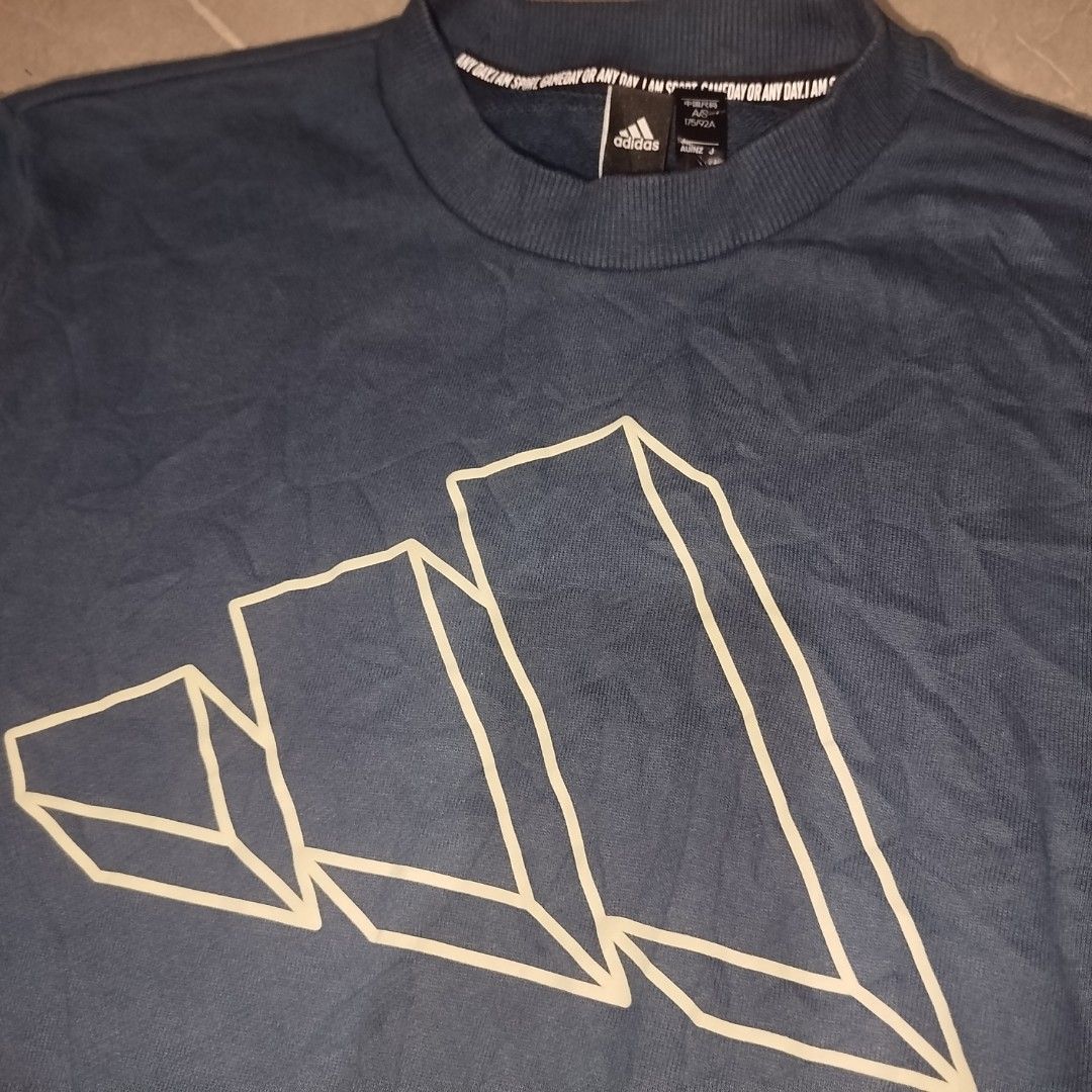 Adidas Blue Graphic Sweatshirt Size M (Category: Coats, Jackets and Outerwear) located in Davao. Submitted by vernoneighty4 (Listing ID 1466482471, Image 3). Description: - Brand: Adidas - Color: Dark blue - Size: US Medium / W20.5 L25Asia S (175/92A) - Design: Large 3D line graphic on chest with 'ANY DAY. I AM SPORT.' neck tape - Details: Ribbed collar, cuffs, and hem - Origin: Made in Cambodia - Condition: Great casual wear for cooler weather.