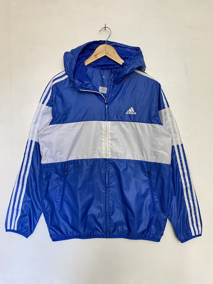 Adidas Blue White Hooded Windbreaker Jacket (Category: Coats, Jackets and Outerwear) located in Cagayan de Oro. Submitted by stllht (Listing ID 1466452192, Image 1). Description: - Brand: Adidas - Color: Classic blue and white color block - Size: L-XL fit -dimes: 22x27.5 - Features: Full zip front, matching hood, zipped side pockets, and breathable mesh lining - Design: Iconic three stripes on sleeves - Condition: Lightweight, perfect for outdoor