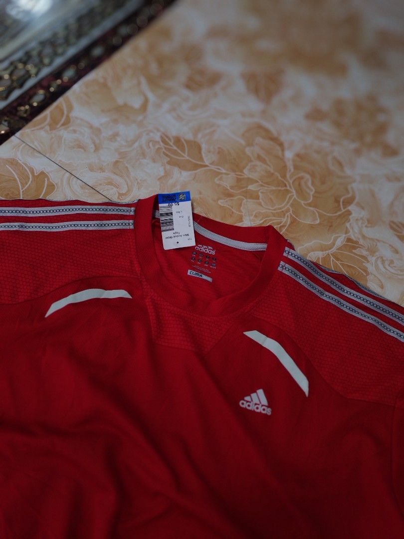 Adidas Climacool Red Athletic T-Shirt (Category: Shirts) located in Baguio. Submitted by eplerkate99908 (Listing ID 1466351428, Image 2). Description: - Brand: Adidas Clima365 - Color: Bright red with white logo and stripes - Condition: Thrift store tag still attached - Material/Design: Breathable honeycomb mesh texture on upper chest - Features: Short sleeves and classic three-stripe shoulder detailing - Ideal for: Gym, running, and athletic tra