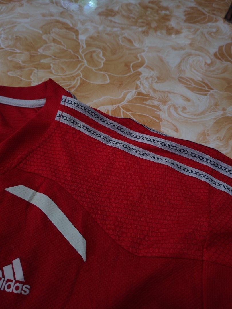 Adidas Climacool Red Athletic T-Shirt (Category: Shirts) located in Baguio. Submitted by eplerkate99908 (Listing ID 1466351428, Image 3). Description: - Brand: Adidas Clima365 - Color: Bright red with white logo and stripes - Condition: Thrift store tag still attached - Material/Design: Breathable honeycomb mesh texture on upper chest - Features: Short sleeves and classic three-stripe shoulder detailing - Ideal for: Gym, running, and athletic tra