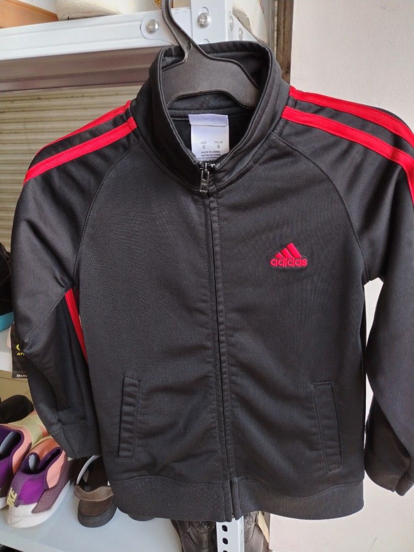 Adidas Kids Black Red Track Jacket Size 6 (Category: Babies & Kids Fashion) located in General Tinio. Submitted by crisantacruz (Listing ID 1466473636, Image 1). Description: - Brand: Adidas - Color: Black with bright red stripes and red embroidered logo - Size: 6 - Material: 100% polyester - Features: Full zip closure, two front hand pockets, ribbed cuffs and hem - Condition: Excellent pre-loved condition - Mode of Payment: GCash - Shipping: Shi