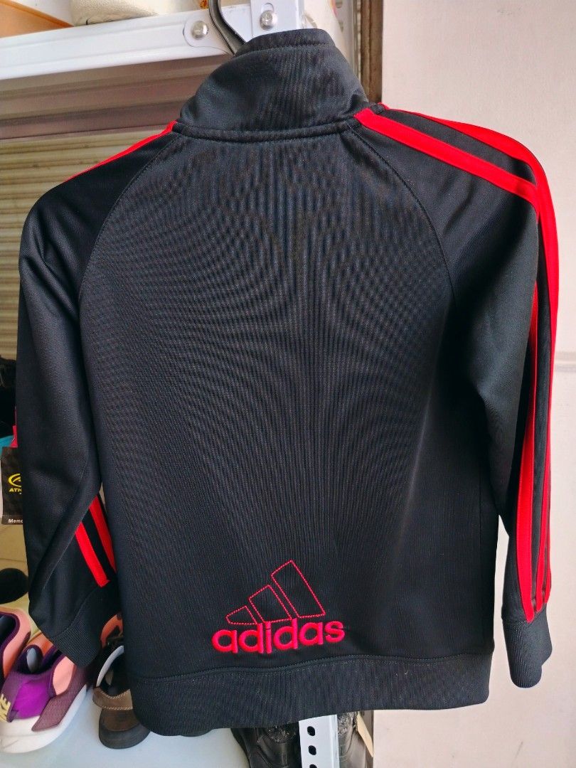 Adidas Kids Black Red Track Jacket Size 6 (Category: Babies & Kids Fashion) located in General Tinio. Submitted by crisantacruz (Listing ID 1466473636, Image 2). Description: - Brand: Adidas - Color: Black with bright red stripes and red embroidered logo - Size: 6 - Material: 100% polyester - Features: Full zip closure, two front hand pockets, ribbed cuffs and hem - Condition: Excellent pre-loved condition - Mode of Payment: GCash - Shipping: Shi