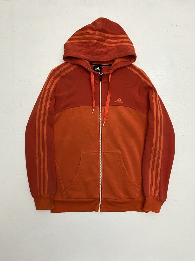 Adidas Performance Essentials Orange Zip-up Hoodie (Category: Coats, Jackets and Outerwear) located in Cagayan de Oro. Submitted by stllht (Listing ID 1466450991, Image 1). Description: - Brand/Line: Adidas Performance Essentials - Color: Bright orange with two-tone color blocking - Size: M on tag best fit L -dimes: 21x27.5 - Design: Classic three stripes running down sleeves and wrapping over the hood - Features: Full zip closure, drawstring hoo