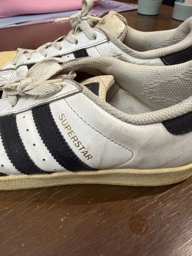 Adidas Superstar White Black Men US 7 (Category: Sneakers) located in Quezon City. Submitted by nsseller (Listing ID 1466460118, Image 3). Description: - Brand: Adidas Superstar - Color: White and Black - Size: US 7 / UK 6.5 / FR 40 / JP 250 / CHN 245 - Features: Classic shell toe design with gold lettering on the side and tongue, Made in Indonesia - Condition: Pre-owned with regular wear, minor scuffs, creasing, and natural yellowing on the rubb