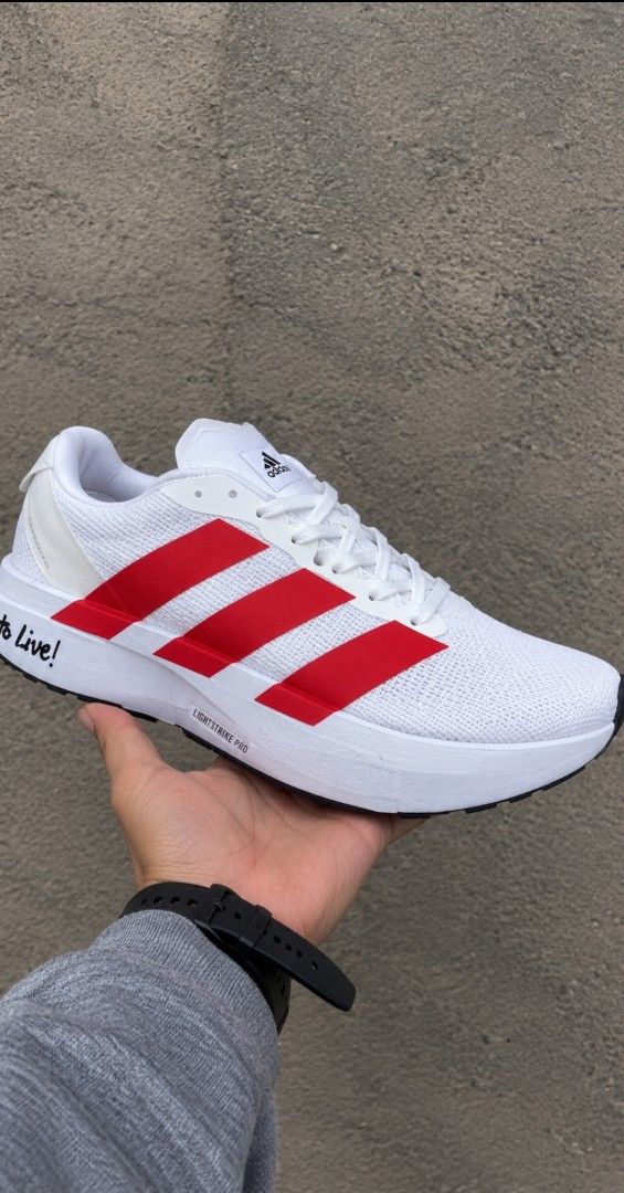 Adidas White Red Lightstrike Pro Running Shoes (Category: Sneakers) located in Manila. Submitted by johnbooc.04 (Listing ID 1466430759, Image 1). Description: - Brand/Model: Authentic Adidas running shoes - Colorway: Crisp white upper with bold red three stripes - Comfort: Responsive Lightstrike Pro cushioning midsole - Upper & Laces: Breathable mesh upper with matching white laces - Details: Unique motivational text near the heel - Outsole: Dura