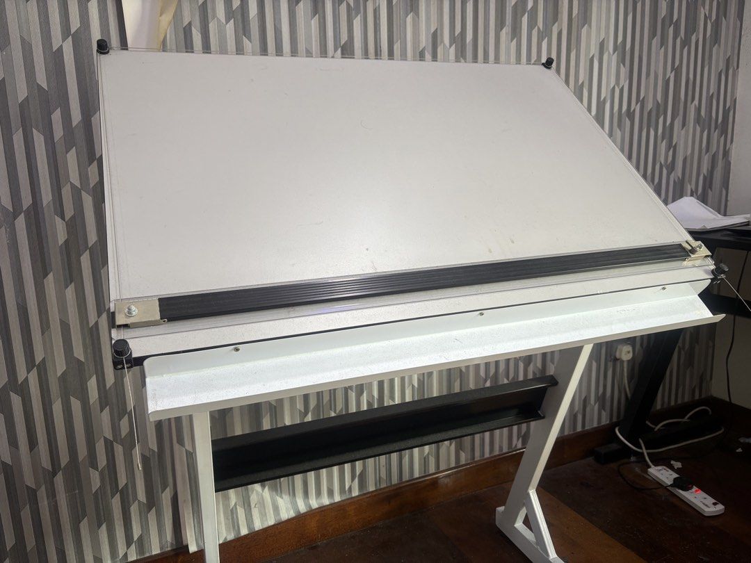 Adjustable Drafting Table (Category: Tables & Sets) located in Kuala Lumpur. Submitted by aimil__ (Listing ID 1466371436, Image 1). Description: ! WTS ! - Large white drafting board with smooth, clean surface - Sturdy metal frame with adjustable angle mechanism - Built-in horizontal parallel motion straightedge - Convenient lower shelf for storage and supplies - Minor signs of prior usage, overall in great working condition Price : RM150 (negotia