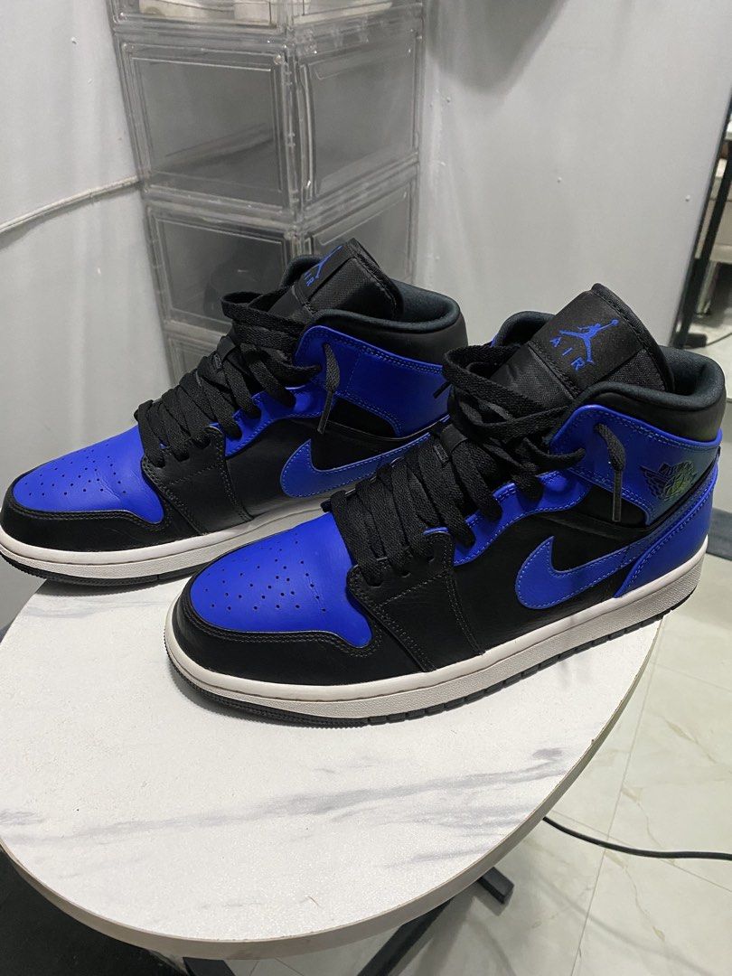 Air Jordan 1 Mid Royal Blue (Category: Sneakers) located in Manila. Submitted by japhetcond32104 (Listing ID 1466518904, Image 2). Description: - Model: Air Jordan 1 Mid - Colorway: Black and Royal Blue - Design: Classic high-top with Jumpman tongue & Wings collar logos - Condition: Minor dust on soles from walking, tread pattern still sharp and intact - Details: Structured toe box, black laces, white midsole, and clean contrast stitching through