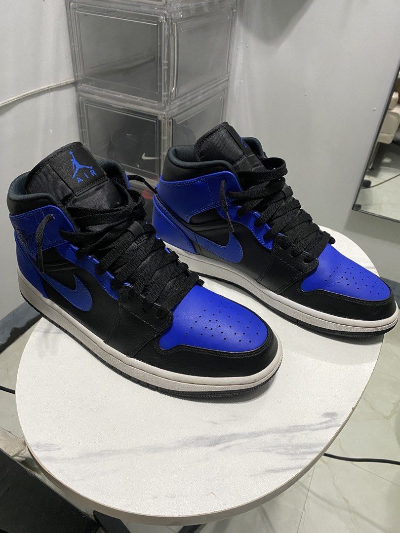 Air Jordan 1 Mid Royal Blue (Category: Sneakers) located in Manila. Submitted by japhetcond32104 (Listing ID 1466518904, Image 3). Description: - Model: Air Jordan 1 Mid - Colorway: Black and Royal Blue - Design: Classic high-top with Jumpman tongue & Wings collar logos - Condition: Minor dust on soles from walking, tread pattern still sharp and intact - Details: Structured toe box, black laces, white midsole, and clean contrast stitching through