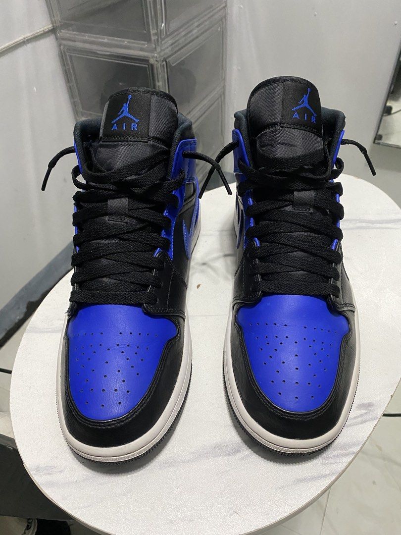 Air Jordan 1 Mid Royal Blue (Category: Sneakers) located in Manila. Submitted by japhetcond32104 (Listing ID 1466518904, Image 1). Description: - Model: Air Jordan 1 Mid - Colorway: Black and Royal Blue - Design: Classic high-top with Jumpman tongue & Wings collar logos - Condition: Minor dust on soles from walking, tread pattern still sharp and intact - Details: Structured toe box, black laces, white midsole, and clean contrast stitching through