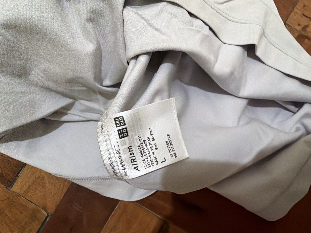 airism uniqlo shirt (Category: Shirts) located in Manila. Submitted by wearagainfinds (Listing ID 1466416222, Image 3). Description: - Color: Light grey and light pink - Sold per piece - Fit: Relaxed, oversized S-L - Design: Crew neckline, short sleeves, and side slits at the hem for easy movement - Fabric: Thick, structured material that holds its shape well - Styling: Versatile neutral tone that pairs great with jeans or joggers.
