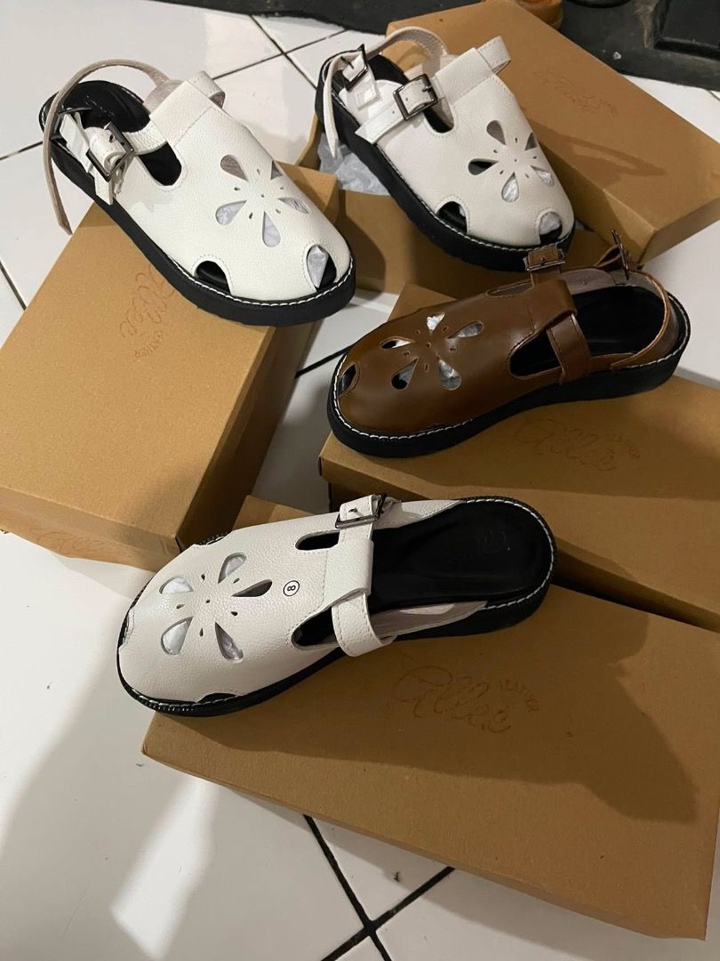 Allee Leather Ann Sandals White (Category: Flats & Sandals) located in San Fernando. Submitted by pamariapineda (Listing ID 1466382650, Image 2). Description: - Brand: Allee Leather - Color/Design: White upper leather with stylish floral cut-out pattern - Style: Slip-on mule with chic buckle strap detail - Sole: Flat black sole featuring contrast white stitching - Original Retail Price: PHP 2,395 - Condition: Brand new / Excellent everyday footwe