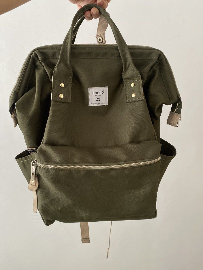 Anello Olive Green Backpack (Category: Backpacks) located in Manila. Submitted by carastaaa (Listing ID 1466428464, Image 1). Description: - Authentic olive green Anello canvas backpack - Signature wide-mouth wire frame opening for easy packing and viewing - Spacious main compartment with convenient rear vertical zipper access - Secure front zipper pocket and dual side slip pockets - Durable fabric with stylish beige accents and snap button handl