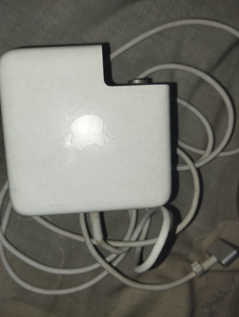Apple 60W MagSafe 2 Power Adapter Model A1435 (Category: Chargers) located in Manila. Submitted by rodderifk (Listing ID 1466549926, Image 1). Description: Original Apple 60W MagSafe 2 power adapter, model A1435. Input 100-240V, output 16.5V 3.65A. White brick with built-in fold-out plug arms and attach cable ending in magnetic 5-pin T-style connector. Shows some scuffs and general dirt buildup from daily use. Cable strain relief intact at both e