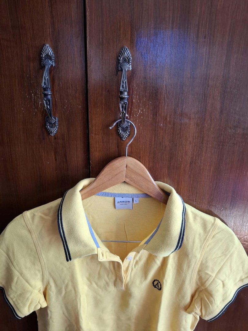 Arrow Yellow Polo Shirt Size L (Category: Tshirts & Polo Shirts ) located in Manila. Submitted by bunbun__ (Listing ID 1466414333, Image 1). Description: - Brand: Arrow - Size: Large (L) - Color: Bright yellow with light blue accent fabric inside the neckline - Details: Contrasting black and white stripes on collar edge and sleeve cuffs - Logo: Small embroidered logo patch on left chest - Closure: Button placket with white buttons - Condition: Ex