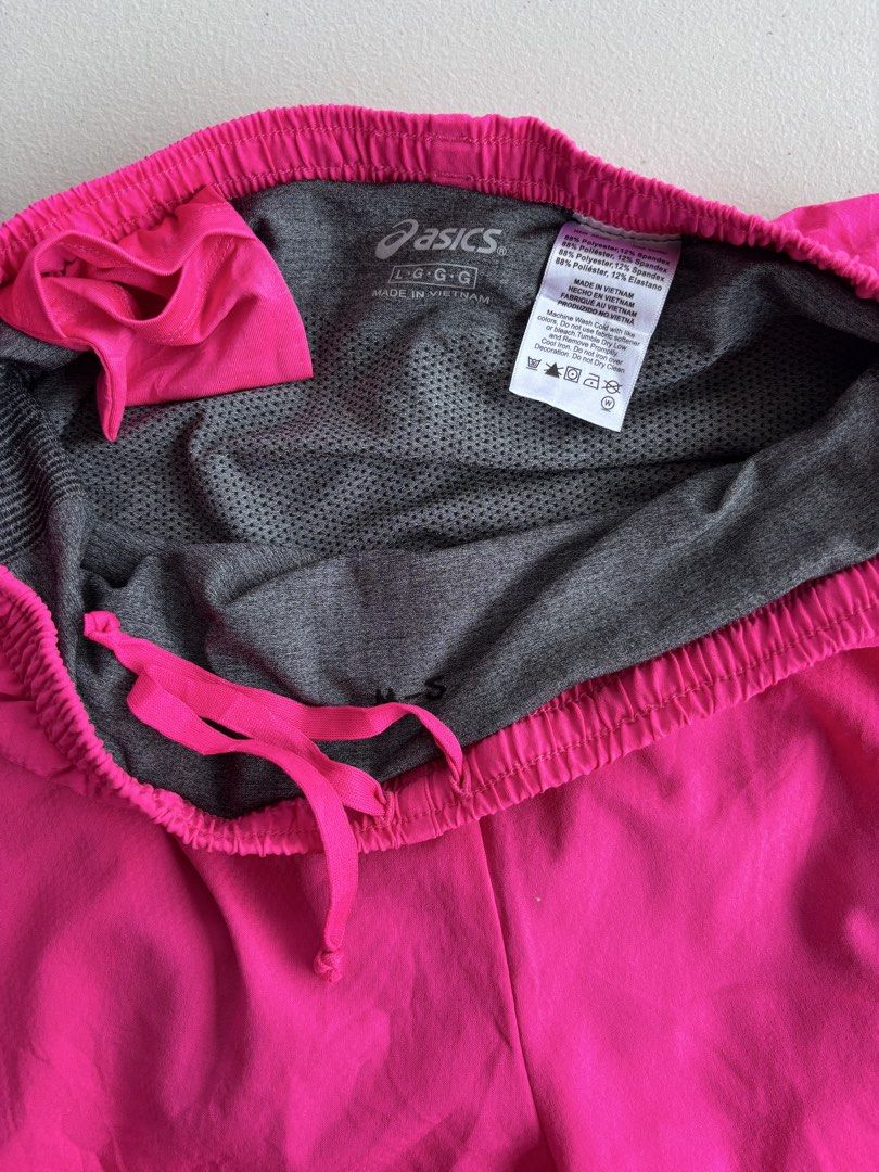 Asics Hot Pink Running Shorts (Category: Activewear) located in Iloilo. Submitted by oddforest.c9c7d5 (Listing ID 1466511710, Image 3). Description: - Brand: Asics - Size: Large - Color: Hot pink with black/white patterned hem - Material: Comfortable polyester and spandex blend (Made in Vietnam) - Features: Built-in gray mesh lining and adjustable pink drawstring - Safety: Reflective Asics logo for low-light visibility - Ideal for: Running, gym w