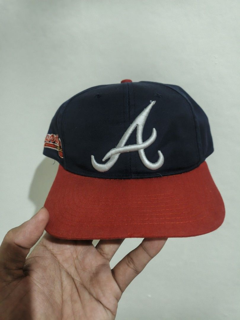 Atlanta Braves MLB Snapback Cap Navy Red (Category: Caps & Hats) located in San Jose. Submitted by ezsenthrift475 (Listing ID 1466351962, Image 1). Description: - Authentic Atlanta Braves snapback cap in navy blue and red - Features embroidered classic 'A' logo on the front and scripted 'Braves' text with tomahawk on the side - Adjustable red plastic snapback closure for a custom fit - Genuine Merchandise label attached inside - Flaw note: White 