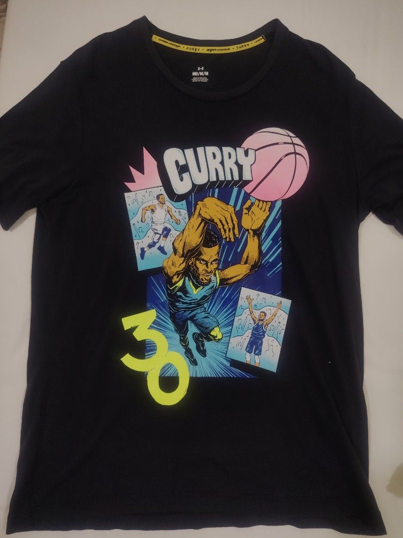 Authentic Under Armour Curry Brand "Comic Book" Graphic Tee (22x29) (Category: Tshirts & Polo Shirts ) located in Pandi. Submitted by thriftcircuit (Listing ID 1466556316, Image 3). Description: 🏀 AUTHENTIC UNDER ARMOUR CURRY BRAND "COMIC BOOK" TEE 🏀 100% Authentic Stephen Curry Brand x Under Armour short-sleeve graphic tee featuring pop-art comic illustrations of Steph shooting, his signature #30, and pink basketball accents. Details: • Brand: