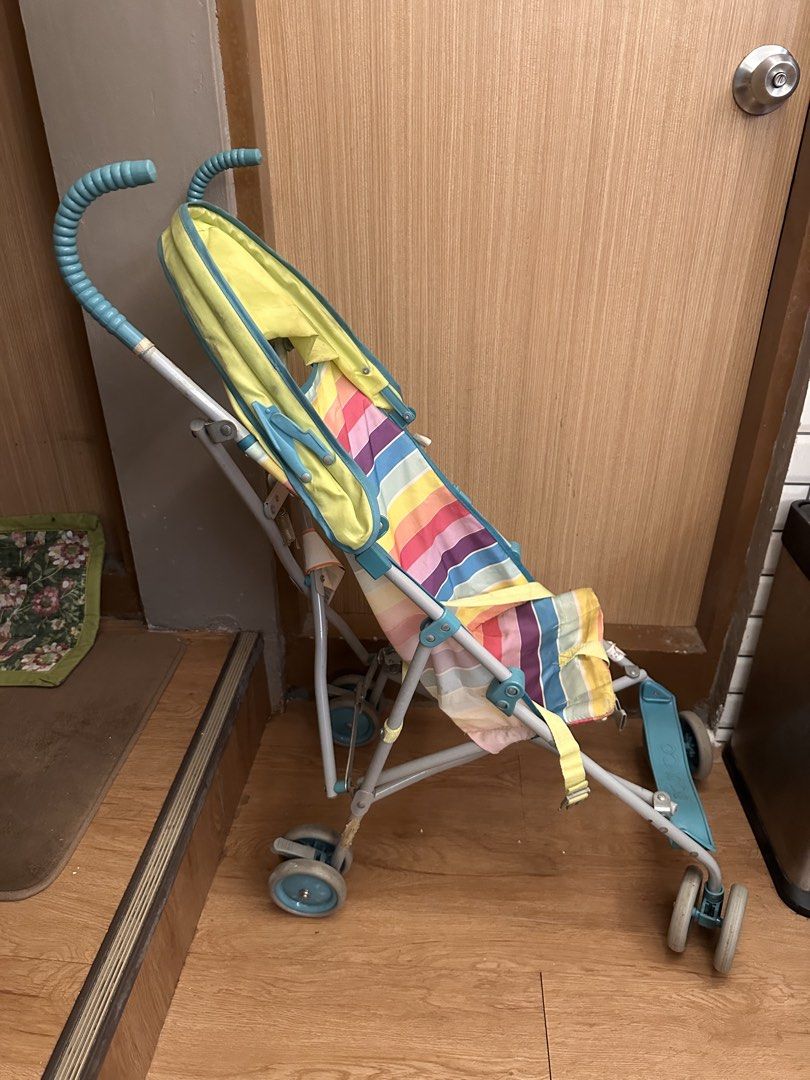 Babyco Stripe Umbrella Stroller (Category: Strollers) located in Quezon City. Submitted by k_prelovedpieces (Listing ID 1466395165, Image 2). Description: - Brand: Babyco - Design: Colorful stripes with bright yellow canopy and teal frame/handles - Type: Lightweight umbrella fold stroller, easy to carry and fits car boots - Safety: Includes attached safety harness - Condition: Shows minor signs of wear and tear on fabric and frame from daily use,