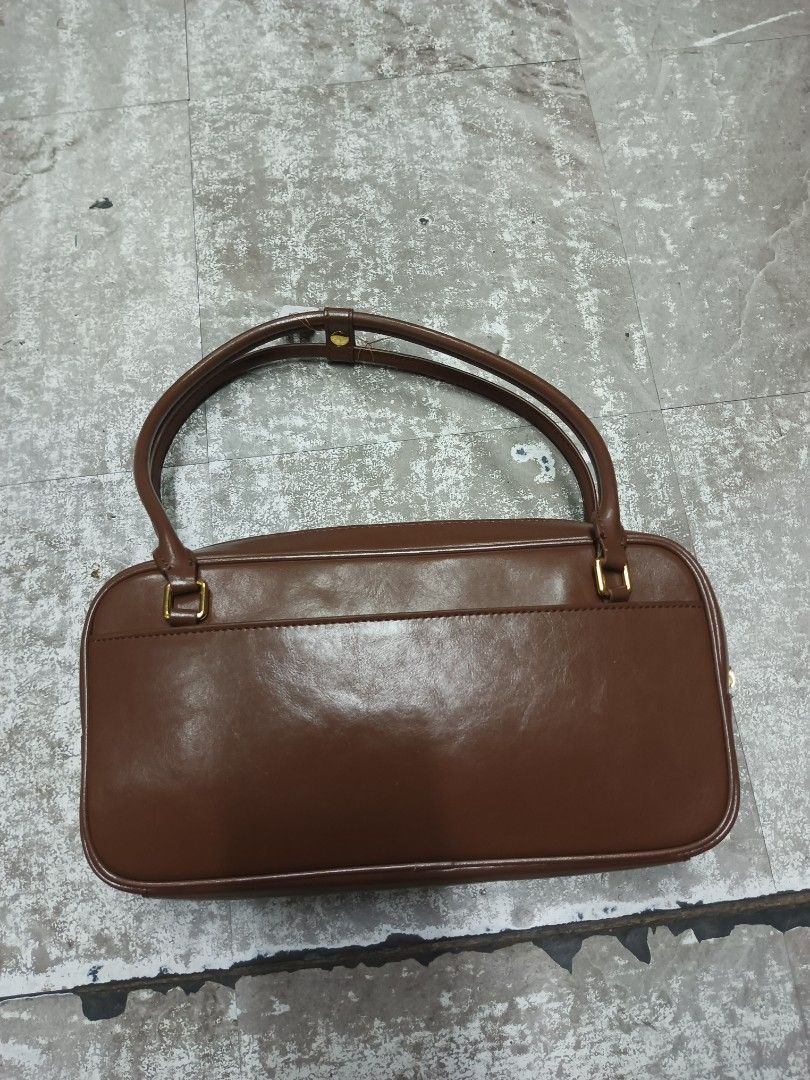 Balenciaga Hourglass Flat Bowling Bag (Category: Luxury Bags & Wallets) located in Baguio. Submitted by brandeditems16 (Listing ID 1466543492, Image 2). Description: - Rich brown leather shoulder bag with a structured rectangular shape - Dual top handles and secure top zipper closure - Eye-catching gold hardware featuring a signature 'B' letter accent on the front pocket - Detailed clean stitching throughout for added durability and style - Great