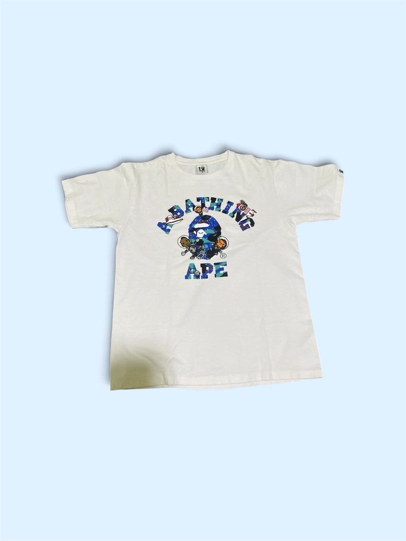 BAPE x Kid Cudi College Moon Tee (Category: Tshirts & Polo Shirts ) located in San Juan City. Submitted by thrifttolife (Listing ID 1466480058, Image 1). Description: - Item: BAPE NY Store 10th Anniversary White T-Shirt - Design: Blue camo graphic print on chest with small logo hit on upper back - Material: 100% soft cotton, comfortable feel - Fit: Standard crew neck, short sleeves - Condition: Excellent / Pre-loved (Please check photos) - Authen