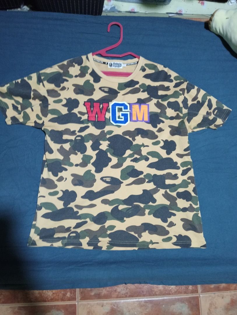 BAPE Yellow Camo WGM Shark Tee (Category: Tshirts & Polo Shirts ) located in Caloocan City. Submitted by yazzielux (Listing ID 1466348307, Image 2). Description: - Brand: BAPE (A Bathing Ape) - Design: Yellow camo with signature back shark face graphic and large WGM chest lettering - Fit: Standard streetwear fit - Details: Short sleeves, crew neck - Authenticity: Includes inner neck tags and wash care labels - Condition: Brand new / Excellent qua