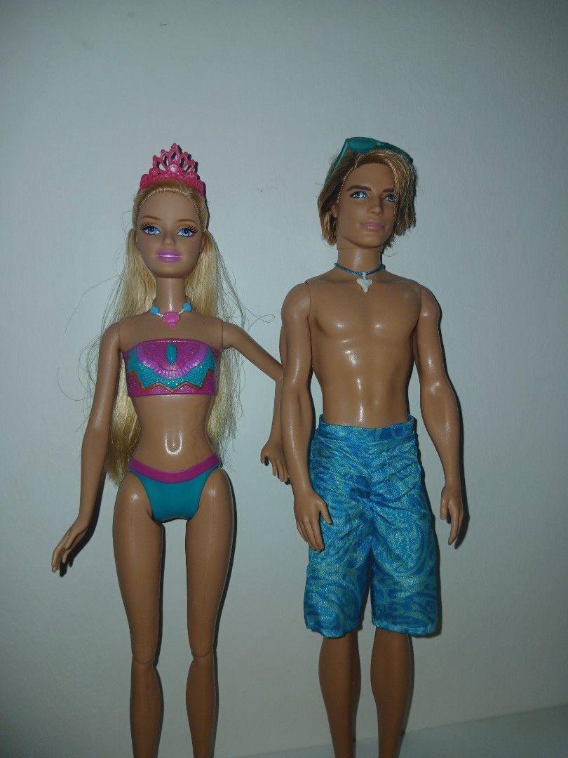 Barbie in a mermaid tail 2 2012 (Category: Kids Toys) located in Subic. Submitted by frncnjntmr22 (Listing ID 1466437805, Image 2). Description: - Barbie and Ken beach doll set - Barbie wears a two-piece swimsuit with pink tiara and necklace - Ken wears blue patterned swim trunks with sunglasses and shark tooth necklace - Includes a vibrant pink surfboard and sparkly pink dolphin toy - Great for imaginative play.