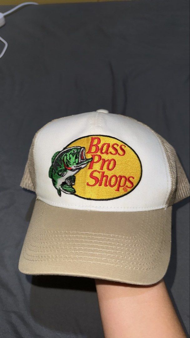 Bass Pro Shops Trucker Hat Snapback Tan White (Category: Caps & Hats) located in Andop. Submitted by nobleangel (Listing ID 1466502008, Image 1). Description: - Authentic Bass Pro Shops trucker hat (Style BPS3254) - Classic tan and white colorway with embroidered bass fish logo - Breathable mesh back panels for all-day comfort - Adjustable plastic snapback closure for a custom fit - One size fits most adults - Clean structured crown and curved br