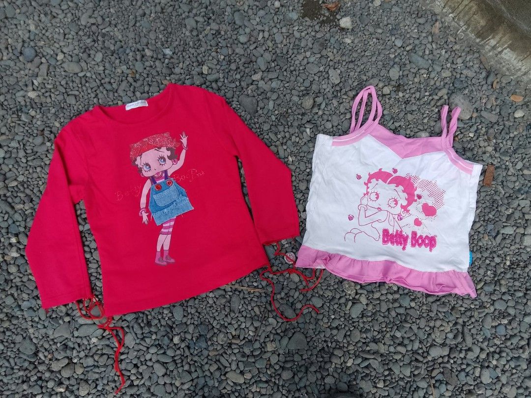 Betty Boop tops bundle Paco Rabanne (Category: Shirts) located in Manila. Submitted by trifted.lootsph (Listing ID 1466462602, Image 1). Description: - Set of 2 cute Betty Boop tops with a trendy Y2K aesthetic - 100% pure cotton material for breathable, all-day comfort - Top 1: Red long-sleeve shirt featuring a Paco Rabanne label, denim pocket detail, and adjustable side tie strings - Top 2: White and pink spaghetti strap camisole with a playful 