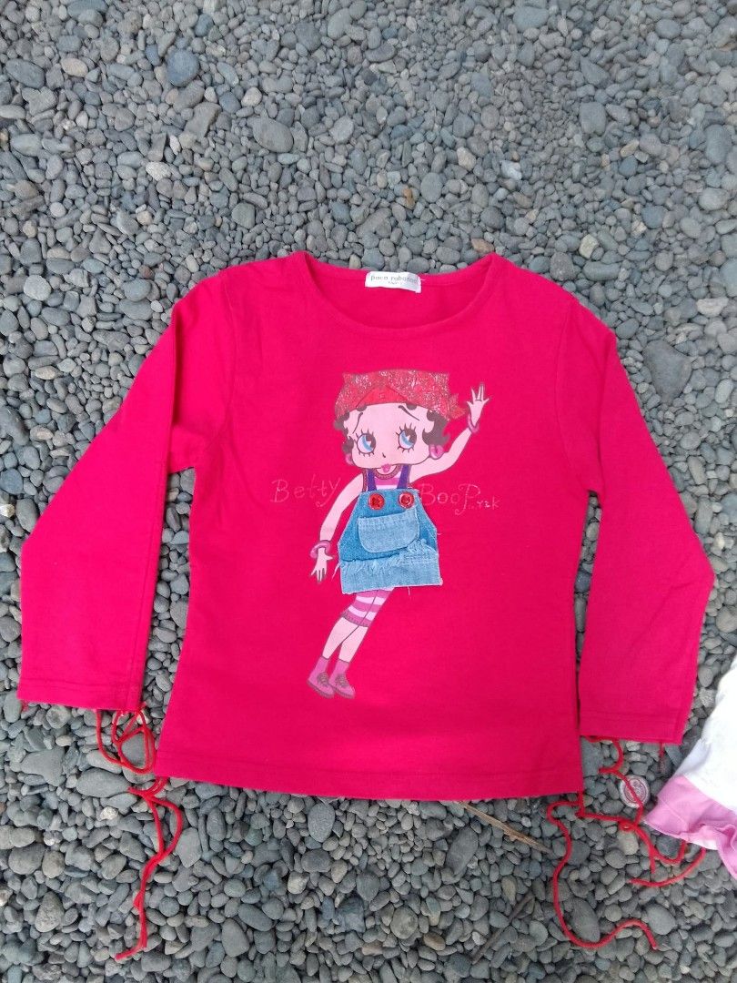 Betty Boop tops bundle Paco Rabanne (Category: Shirts) located in Manila. Submitted by trifted.lootsph (Listing ID 1466462602, Image 3). Description: - Set of 2 cute Betty Boop tops with a trendy Y2K aesthetic - 100% pure cotton material for breathable, all-day comfort - Top 1: Red long-sleeve shirt featuring a Paco Rabanne label, denim pocket detail, and adjustable side tie strings - Top 2: White and pink spaghetti strap camisole with a playful 