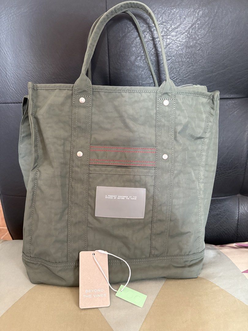 Beyond The Vines Crunch Carryall Sage M (Category: Tote Bags) located in Quezon City. Submitted by brandedthingsforless (Listing ID 1466358848, Image 2). Description: - Brand: Beyond The Vines - Style: Crunch Carryall - Size: Medium - Color: Sage with contrasting red stitch accents - Condition: Brand new with original tags - Features: Secure zippered top closure, roomy interior, durable fabric construction, sturdy double handles, and a convenient