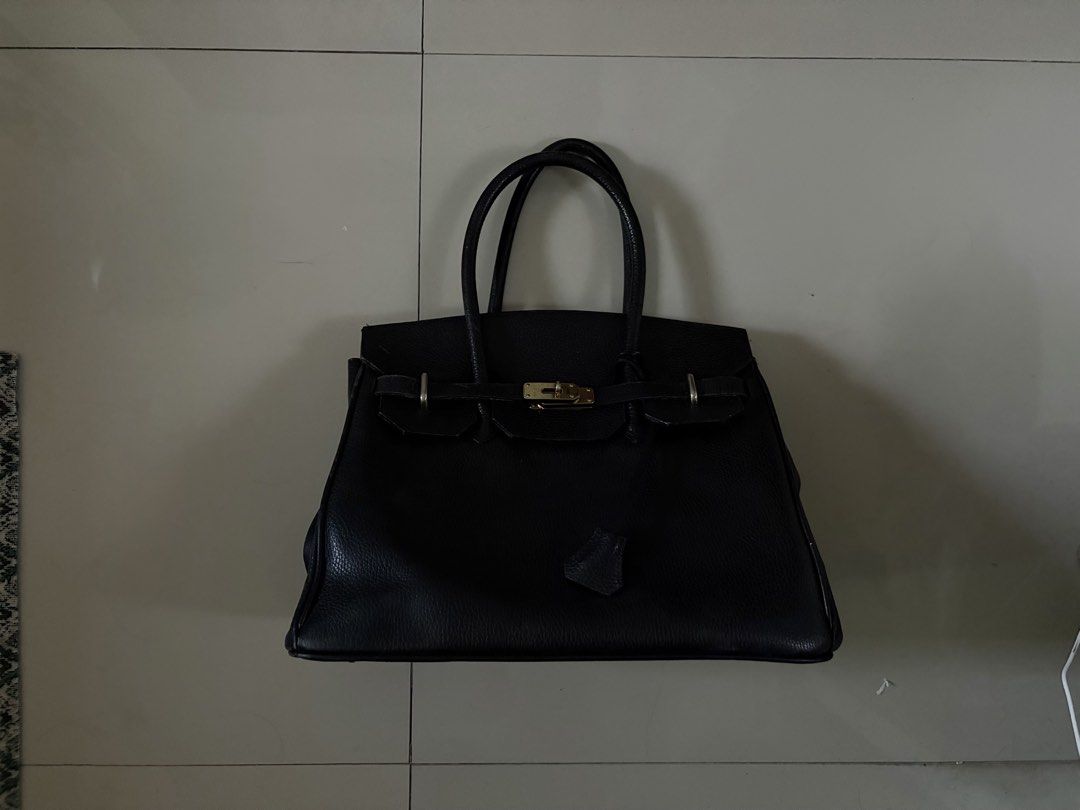 Birkin black leather bag (Category: Luxury Bags & Wallets) located in Manila. Submitted by t0rturedzia (Listing ID 1466559720, Image 1). Description: - Color: Timeless Black - Material: Soft textured leather with visible grain - Design: Structured shape with sturdy edge stitching - Hardware: Gold-tone lock closure, straps, and matching accents - Handles: Double top handles with an included dangling clochette - Interior: Roomy compartment, perfect