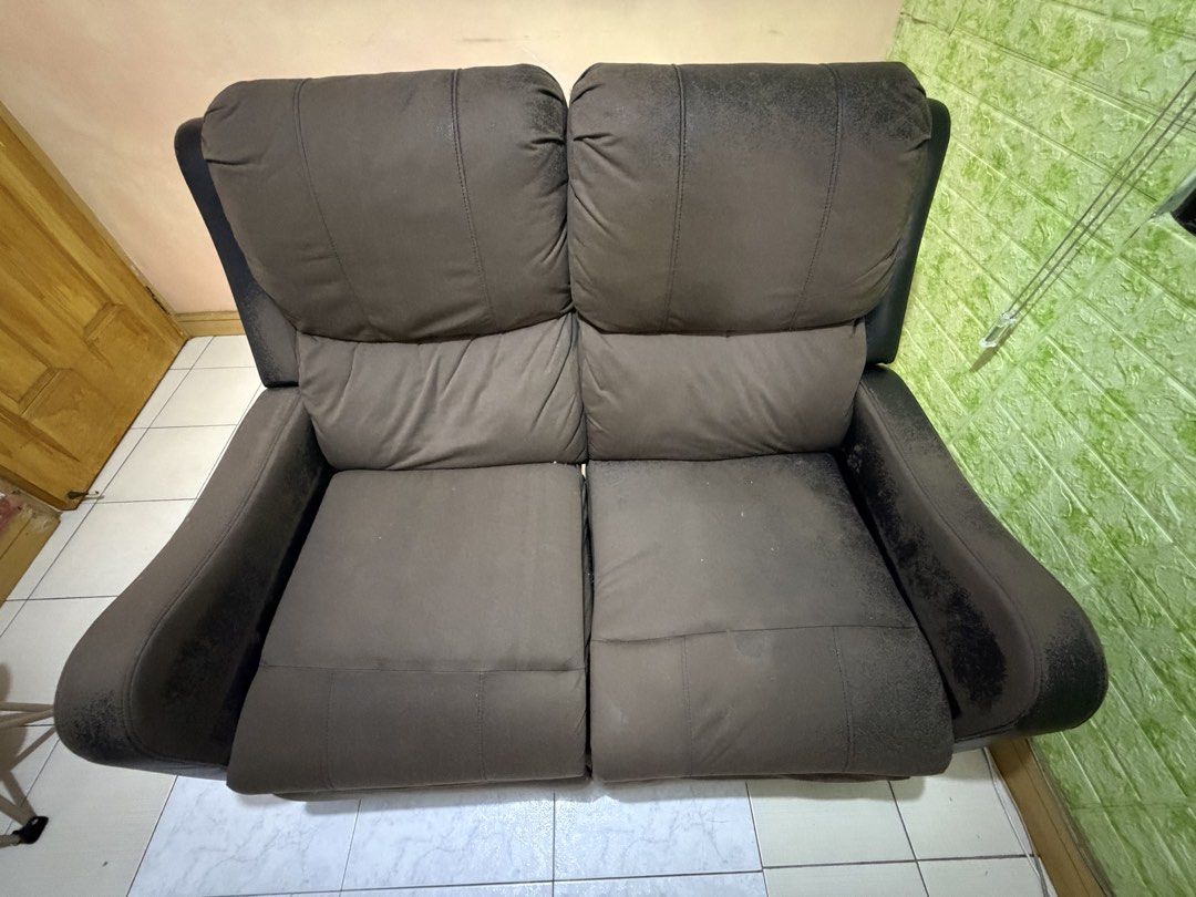Black 2-Seater Recliner Sofa (Category: Sofas) located in Agdangan. Submitted by eun_zurc (Listing ID 1466469768, Image 1). Description: - Type: Two-seater recliner sofa - Color: Black - Mechanism: Manual pull handle for footrests - Comfort: Plush back cushions and armrests - Condition: Sturdy frame and working recline function, but upholstery has heavy wear, flaking, and peeling on arms, top edges, and footrests - Ideal for: Budget buyers, DIY r