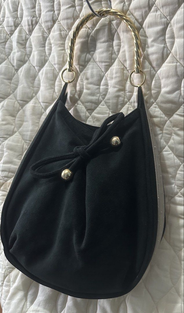 Black Gamuza leather Handbag (Category: Luxury Bags & Wallets) located in Santa Rosa. Submitted by esplanamur03635 (Listing ID 1466388627, Image 3). Description: Chic black suede(gamuza leather) hand/kili bag beige ostrich-textured side panels twisted gold metal top handle. front tie detail with gold accents Perfect for everyday or casual events! (can be worn as shoulder bag -for petite women) Yoshinoya brand original japan bag Classy and excelle