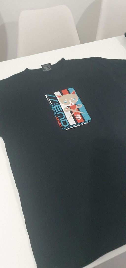 Black Graphic T-Shirt Cat Design (Category: Shirts) located in Quezon City. Submitted by sk8ter13 (Listing ID 1466436195, Image 3). Description: - Color: Black - Design: Front graphic print with a cartoon cat and edgy text ("blood metal magic", "paradise of end") - Fit: Regular fit with short sleeves and standard crew neck - Style: Casual, streetwear, unique graphic apparel - Condition: Brand new / Excellent.