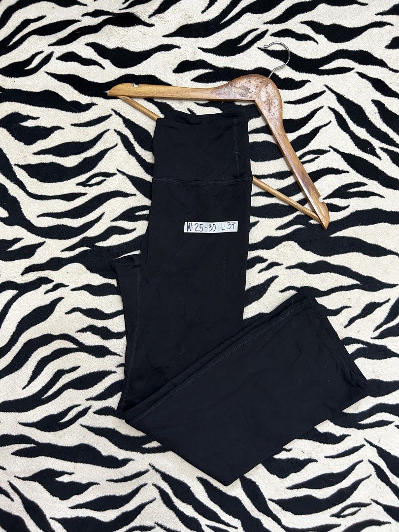Black high-waisted flared workout pants (Category: Activewear) located in Valencia. Submitted by crizzagella20 (Listing ID 1466500389, Image 2). Description: Black flared workout pants, high-waisted fit with a wide waistband. White logo printed on the back center waist. Smooth stretchy fabric with a split flared hem at the bottom of each leg. Measurements written on the tag label attached near the hip. Clean solid black colour throughout..